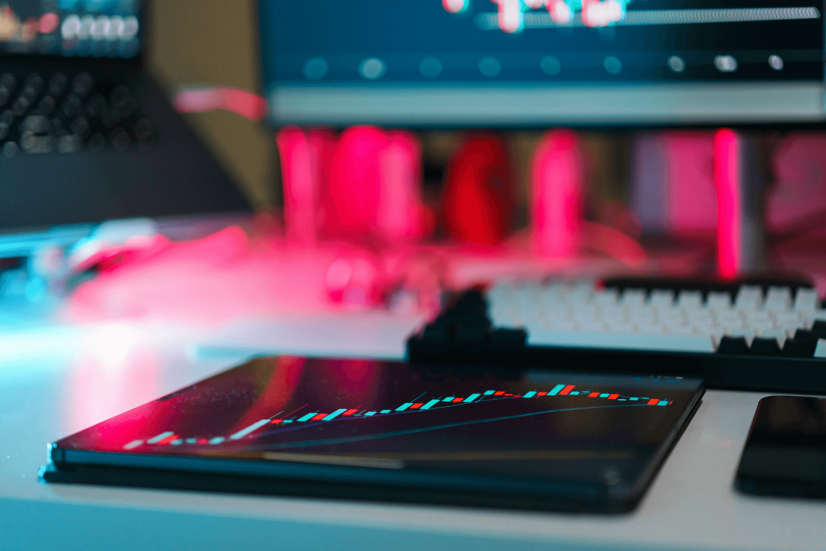 A trading chart glowing against a dark workspace